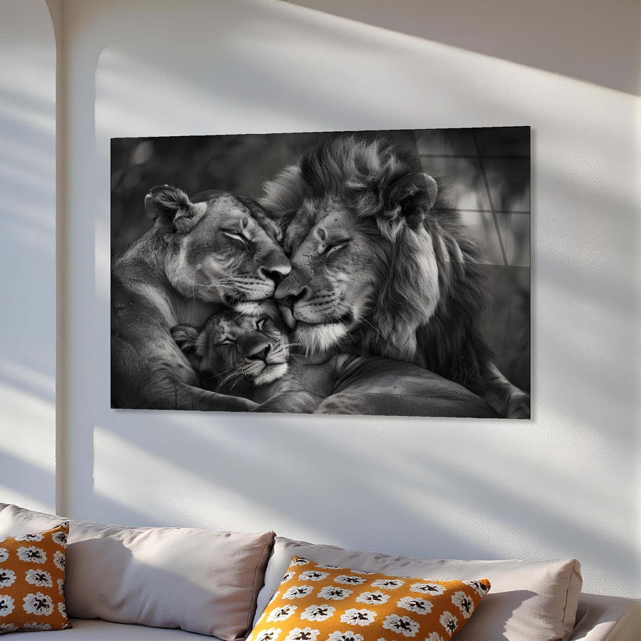 Black and white photo of a lion family on a wall above a sofa with patterned cushions.