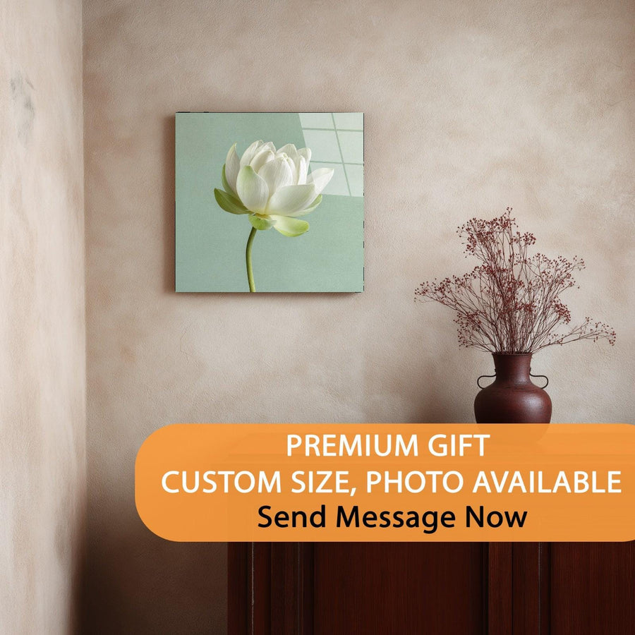 Wall art of a white flower on a light green background, displayed on a beige wall with a vase of dried flowers.