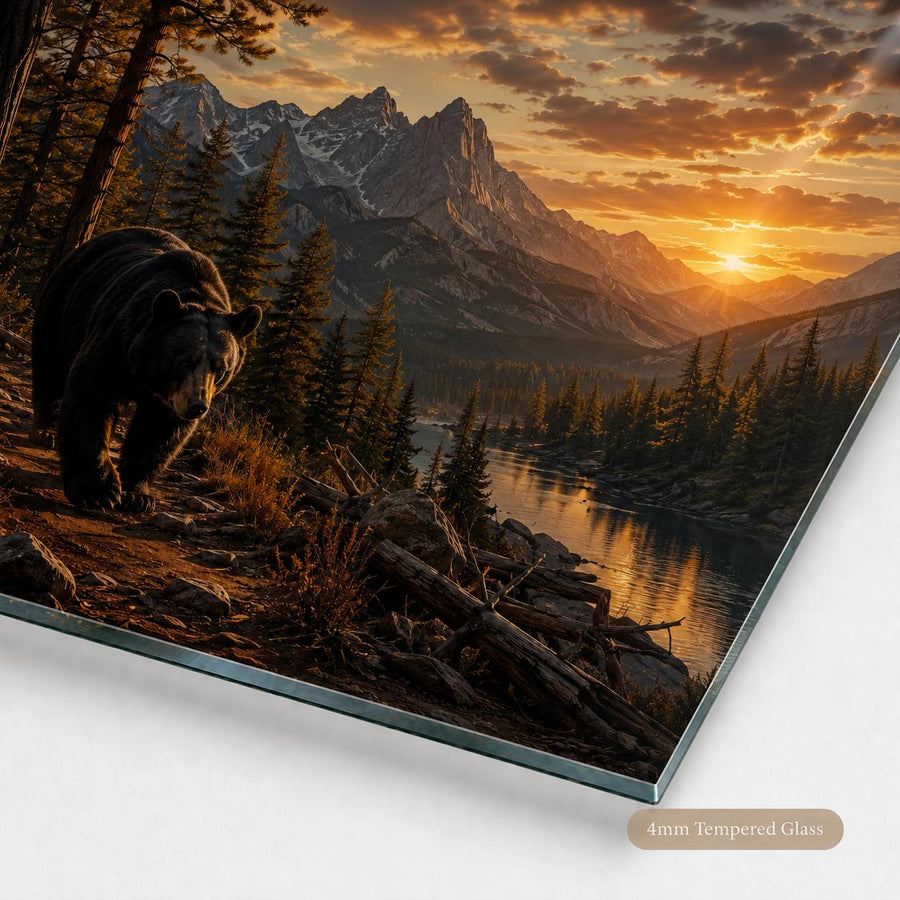A rectangular glass wall art panel showing a dramatic mountain landscape at sunset with a bear in the foreground, photographed at an angle on a white background. A small label at the bottom right reads '4mm Tempered Glass'.