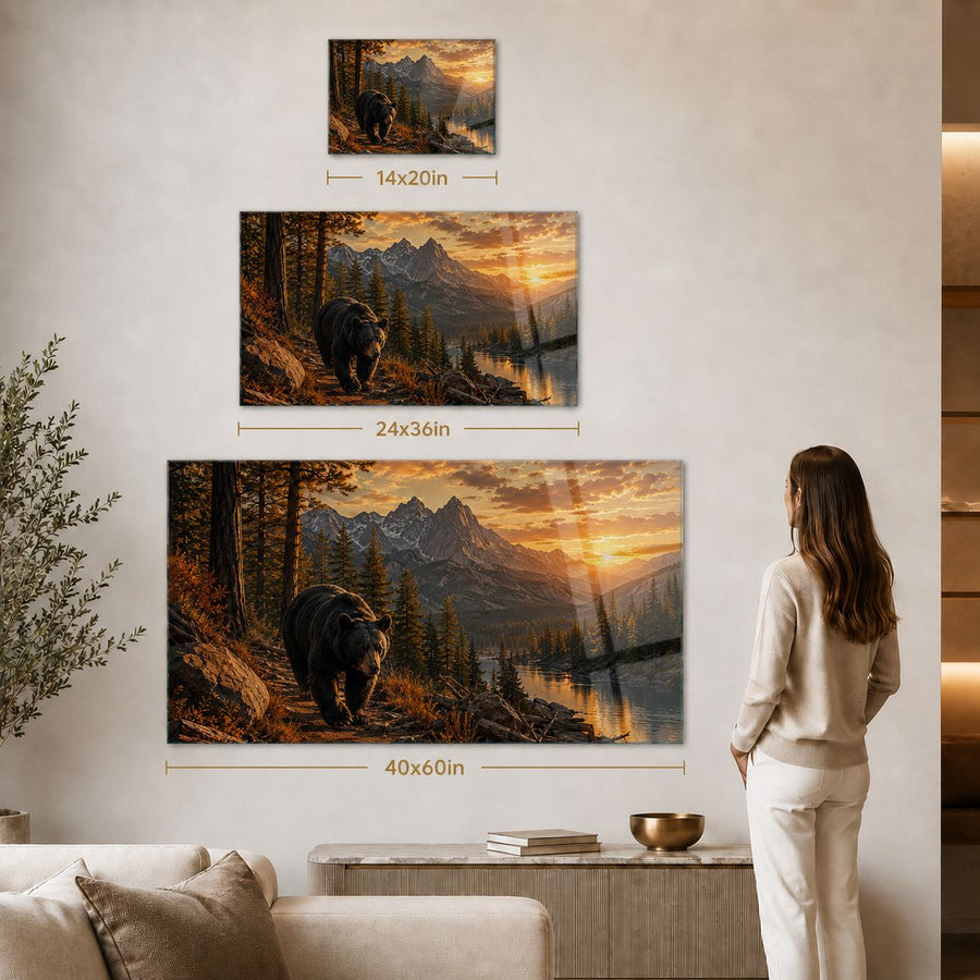 Three framed wall art prints showing a bear in a mountain landscape, displayed on a beige wall in a living room. The largest print is mounted centrally, with two smaller prints above it.