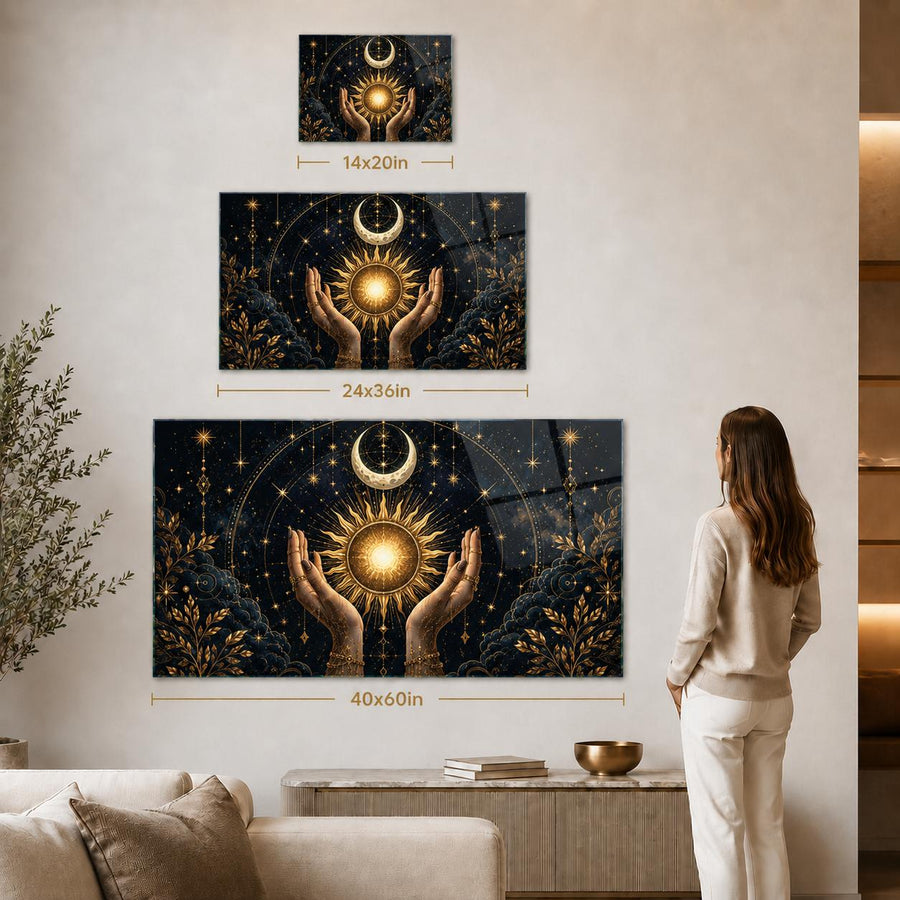 A woman stands in a living room facing a large wall-mounted artwork, with two smaller versions shown above it to indicate size. The artwork depicts two raised hands holding a glowing sun and moon against a dark celestial background.