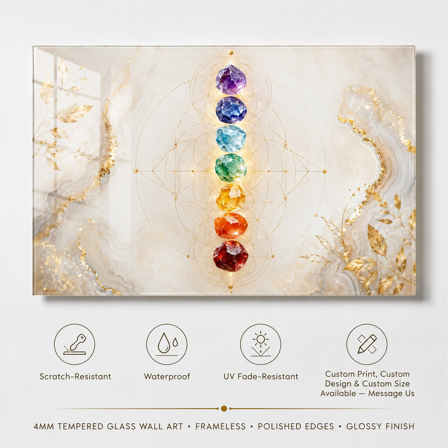 A framed wall art print featuring a chakra-style vertical row of faceted gemstones in purple, blue, green, yellow, orange, and red on a soft cream marble background with gold geometric lines and gold leaf accents. Below the artwork, feature icons and text mention scratch resistance, waterproofing, UV fade resistance, custom print/design, and 4mm tempered glass wall art with a glossy finish.