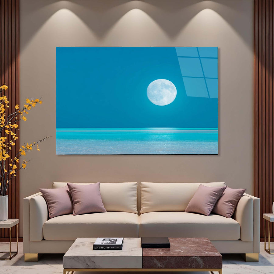 Modern living room with a beige sofa, decorative pillows, and a large wall art piece depicting a moon over water.