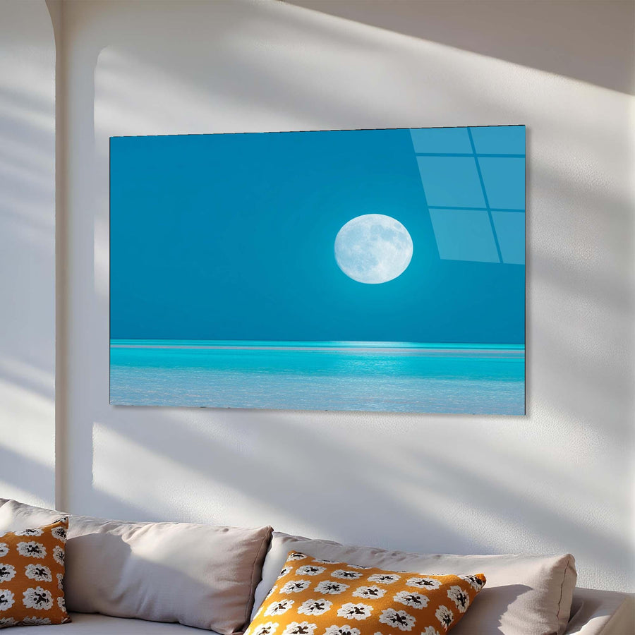 TV screen displaying a moon over water scene in a room with a sofa and pillows.