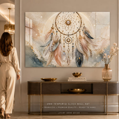 A rectangular wall art print or canvas featuring a dreamcatcher design in soft pastel tones, shown hanging against a plain light wall. The artwork includes a large circular dreamcatcher with feathers in blush pink, gray, cream, and gold, plus subtle watercolor-like background washes and small sparkles.